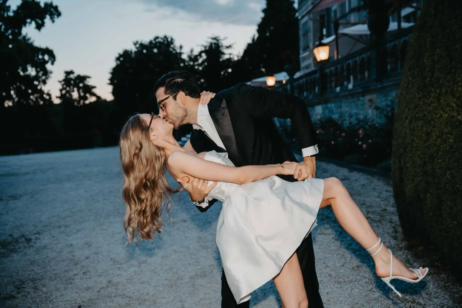 Jana und Murat küssen sich in der Abenddämmerung vor der Villa Rothschild